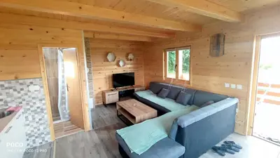 a living room with a blue couch and a tv at Brvnara Gold Hill in Prijedor