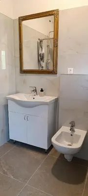 a bathroom with a sink and a mirror and a toilet at Apartman Bihać SviMi in Bihać