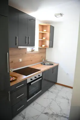 a kitchen with black cabinets and a sink at Vila Mir in Banja Vrućica