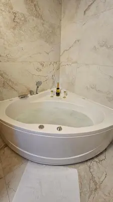 a white bath tub in a bathroom with marble walls at Vila Mir in Banja Vrućica