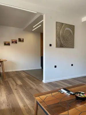 a room with a table and a painting on the wall at Apartman Lana in Teslić