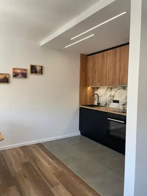 a kitchen with white walls and wooden cabinets at Apartman Lana in Teslić
