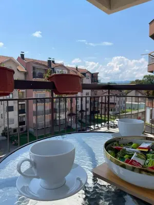 a table with cups and a bowl of food on a balcony at Apartman Lana in Teslić