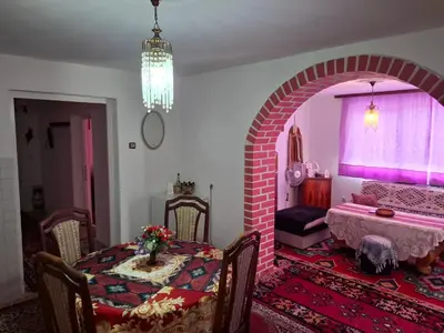 a dining room with a table and a brick archway at Retro Retreat Izačić in Bihać