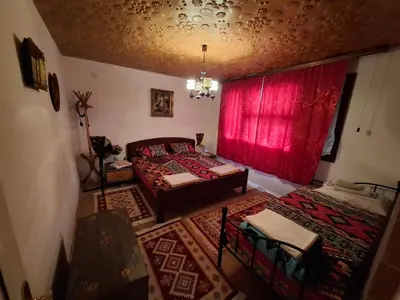 a bedroom with a bed and a red curtain at Retro Retreat Izačić in Bihać
