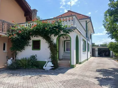a white house with flowers on the side of it at Retro Retreat Izačić in Bihać
