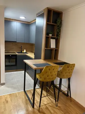 a kitchen with a wooden table and two chairs at HeraLux in Doboj