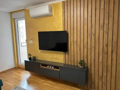 a living room with a television on a wooden wall at HeraLux in Doboj