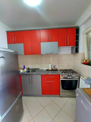 a kitchen with red cabinets and a stainless steel refrigerator at Apt Iva 2 in Banja Luka