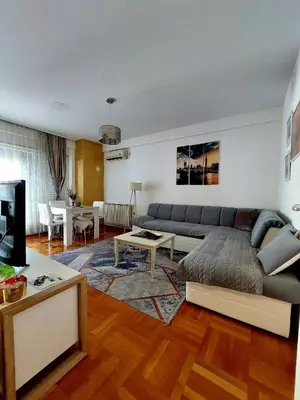 a living room with a couch and a living room with a table at Apt Iva 2 in Banja Luka