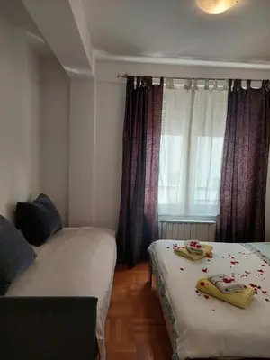 two beds in a room with a window at Apt Iva 2 in Banja Luka