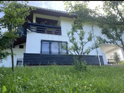a white house with a balcony and a yard at Vila Ponijeri in Kakanj
