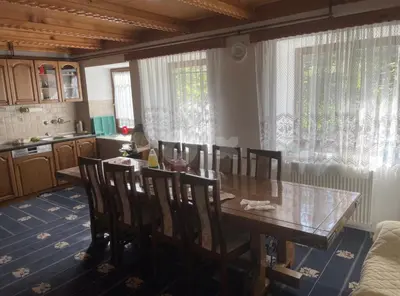 a dining room with a wooden table and chairs at Vila Ponijeri in Kakanj