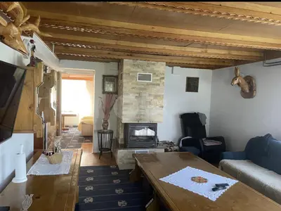 a living room with a table and a fireplace at Vila Ponijeri in Kakanj