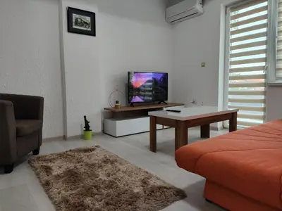 a living room with a bed and a tv and a table at Vista in Živinice