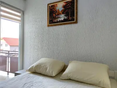 a bedroom with a bed with a painting on the wall at Vista in Živinice