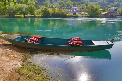a blue boat sitting on the shore of a lake at Holiday Homes Mujo Bejzin in Račić