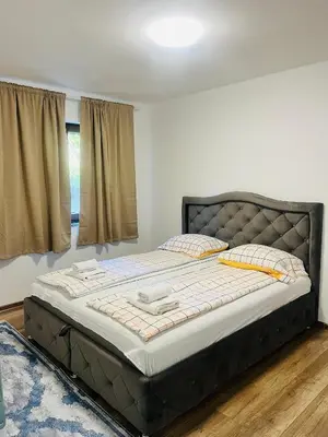 a large bed in a bedroom with a large window at Villa Casa de Dina in Bihać