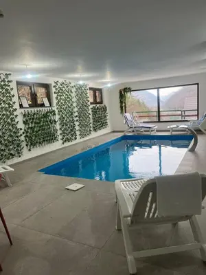 a swimming pool in a room with chairs and a table at Villa Casa de Dina in Bihać