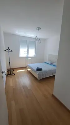 a bedroom with a bed and a wooden floor at Apartman Giro in Banja Luka