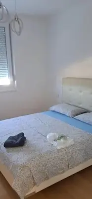 a bed with a blue blanket and a hat on it at Apartman Giro in Banja Luka