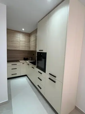 a kitchen with white cabinets and a black appliance at Apartmani Bare in Jajce