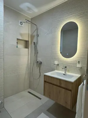 a bathroom with a sink and a shower with a mirror at Apartmani Bare in Jajce