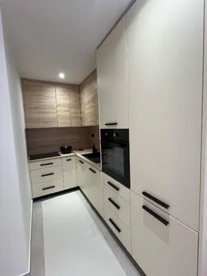 a kitchen with white cabinets and a black oven at Apartmani Bare in Jajce