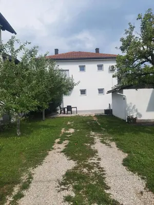 a large white building with a grass yard at Apartments White House Bihac in Bihać
