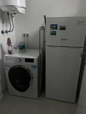 a white refrigerator and a washing machine in a kitchen at Apartments White House Bihac in Bihać