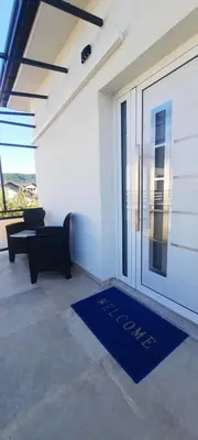 a living room with a blue welcome mat in front of a door at Apartments White House Bihac in Bihać