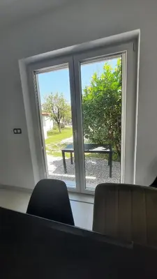a room with two windows and a table outside at Apartments White House Bihac in Bihać
