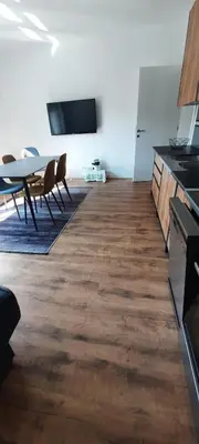 a room with a table and chairs and a tv at Apartments White House Bihac in Bihać
