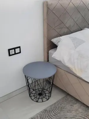 a bed with a stool next to a bed at Apartments White House Bihac in Bihać