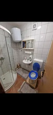 a bathroom with a blue toilet and a sink at Winter Forest Vlasic in Šišava