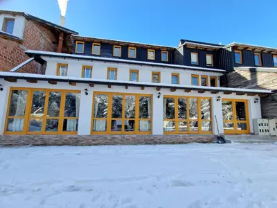 a large building with large windows in the snow at Winter Forest Vlasic in Šišava