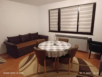 a living room with a table and a couch at Apartment Happy Corner in Visoko