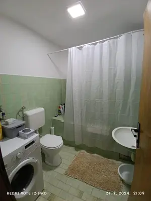 a bathroom with a toilet and a sink and a shower at Apartment Happy Corner in Visoko