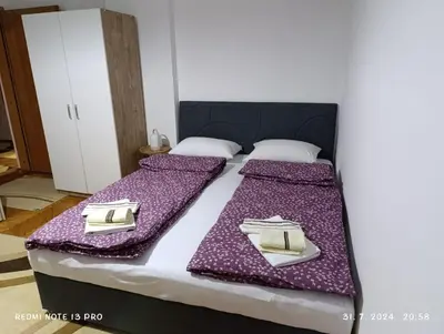 a bedroom with a bed with purple sheets and gold napkins at Apartment Happy Corner in Visoko
