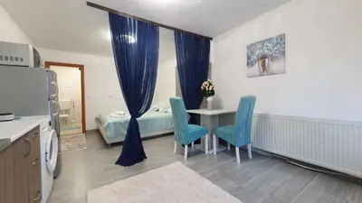 a room with a table and chairs and a bed at Studio Apartman Mint Bihac in Bihać