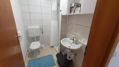 a small bathroom with a toilet and a sink at Studio Apartman Mint Bihac in Bihać