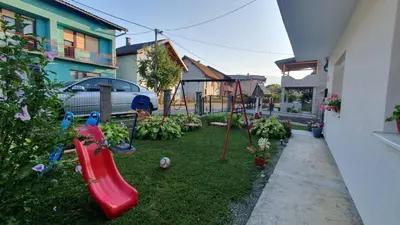a backyard with a playground with a red slide at Studio Apartman Mint Bihac in Bihać