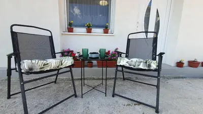 two chairs and a table in front of a window at Studio Apartman Mint Bihac in Bihać