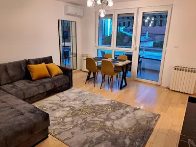 a living room with a couch and a table and chairs at Premier Apartment in Banja Luka