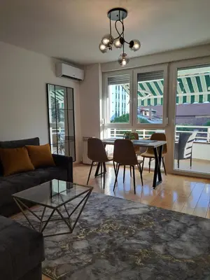 a living room with a couch and a table and chairs at Premier Apartment in Banja Luka