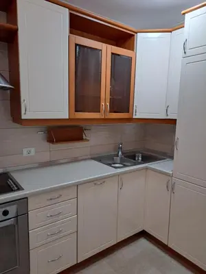 a kitchen with white cabinets and a sink at Premier Apartment in Banja Luka