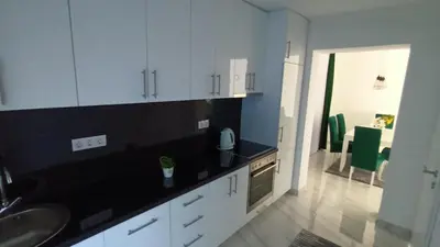 a kitchen with white cabinets and a black counter top at 