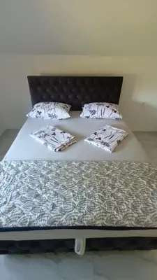 a large bed with white sheets and pillows on it at 