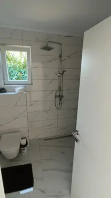 a bathroom with a shower and a toilet and a window at 