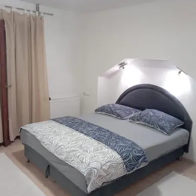 a bed with blue and white sheets and pillows at Petra in Livno